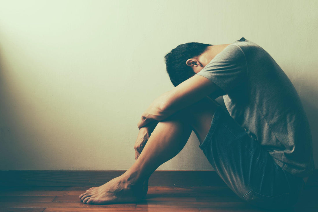 Person sitting alone in a dimly lit room looking reflective, representing the emotional and mental challenges of alcohol recovery beyond willpower.